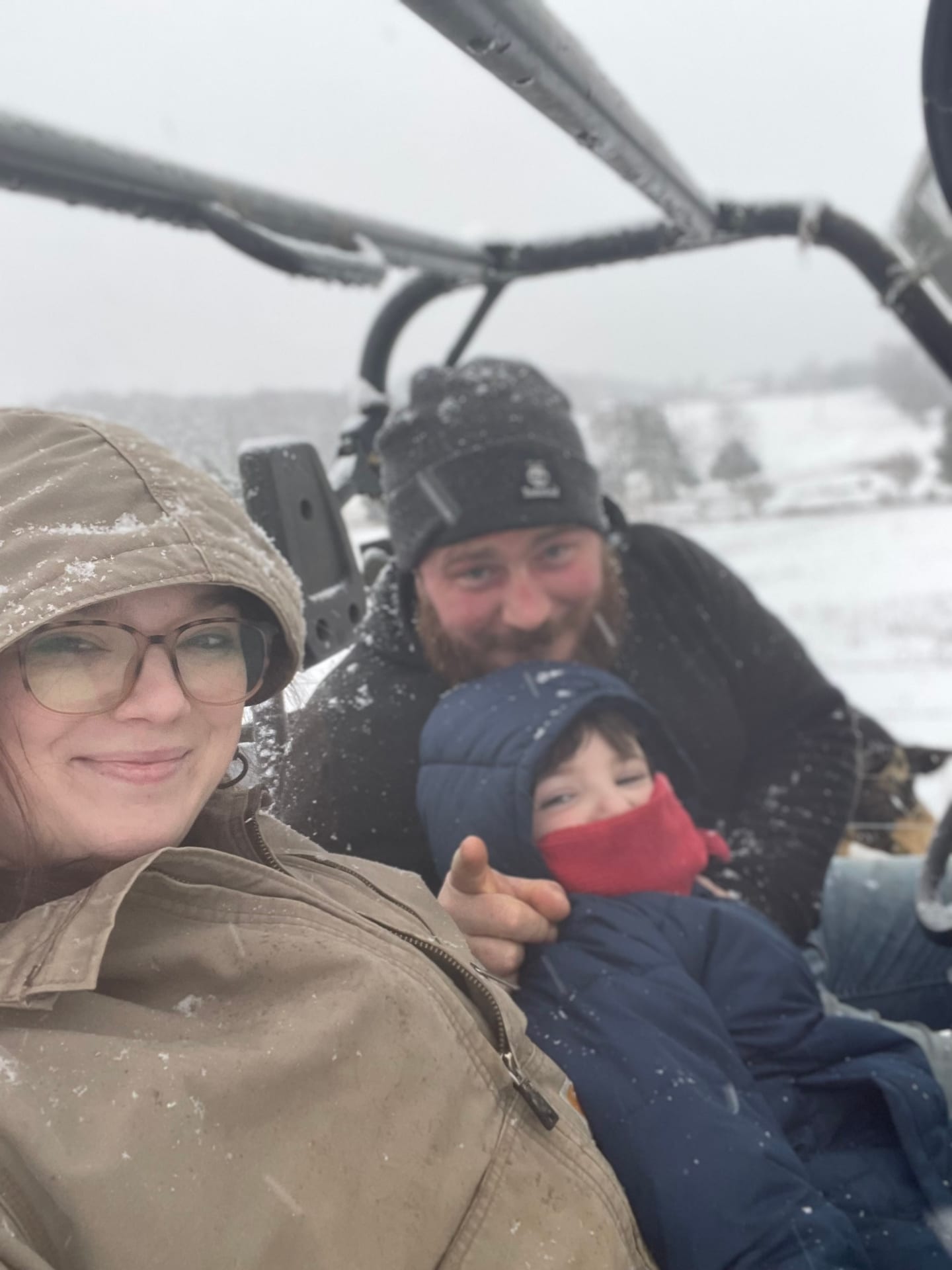 The Long Branch Farms family bundled up together in a snow-covered farm vehicle